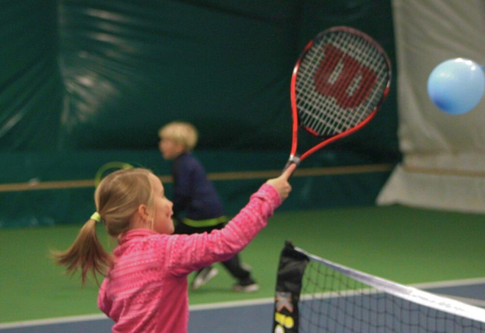 Lapset pelaamassa tennistä ilmapallolla